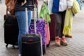 een groep toeristen die met hun koffers staan te wachten