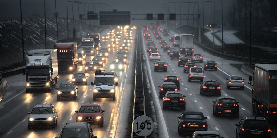 Snelweg met auto's en vrachtauto's in de spits