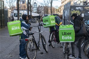 Uber Eats bicycle couriers awaiting orders before delivering them to customers.