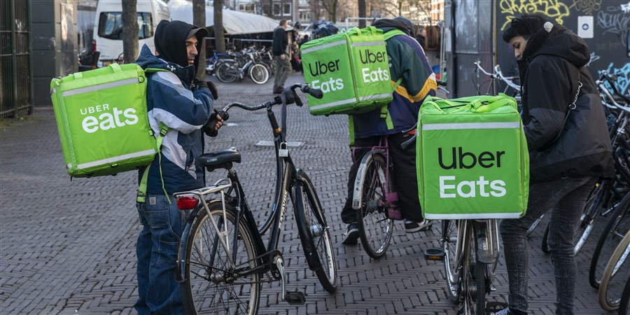 Uber Eats bicycle couriers awaiting orders before delivering them to customers.