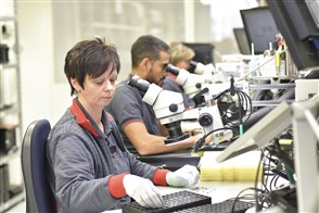 Vrouw aan het werk op de kwaliteitscontrole in de electronische industrie