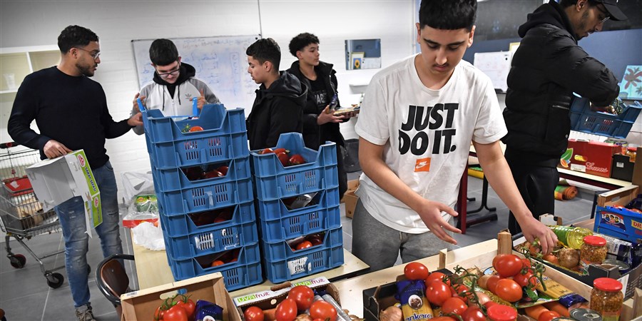 Jongeren in Arnhem helpen bij het inpakken van pakketten voor de voedselbank