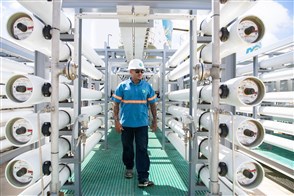 Man loop tussen buizen in waterleidingbedrijf